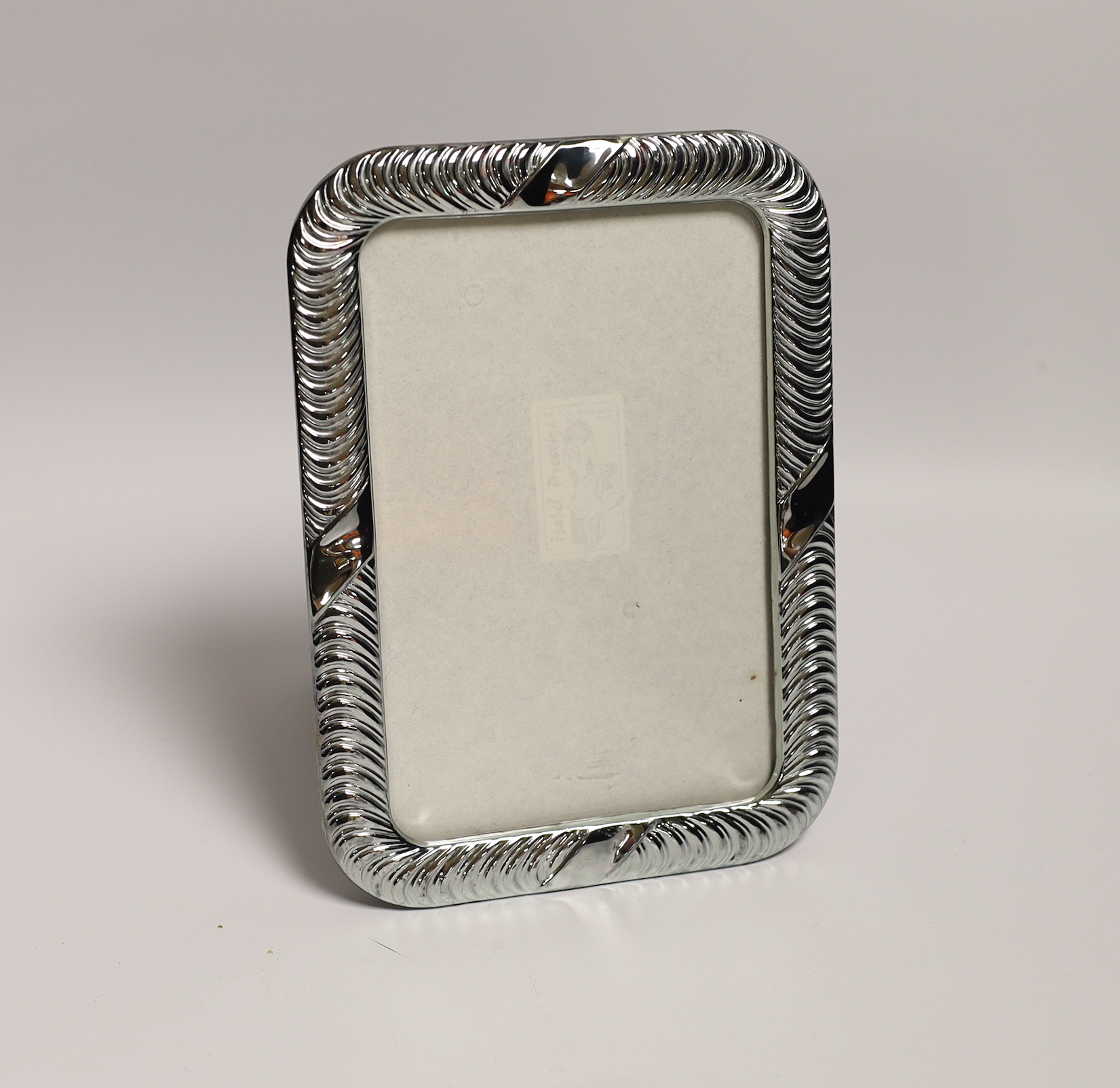 Sundry small silver including a pair of dwarf candlesticks, condiments, napkin ring, spill vases and a modern 925 mounted photograph frame.